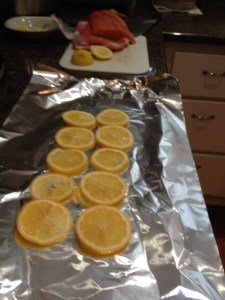 Start by lining a sheet of aluminum foil with lemon slices