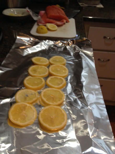 Start by lining a sheet of aluminum foil with lemon slices